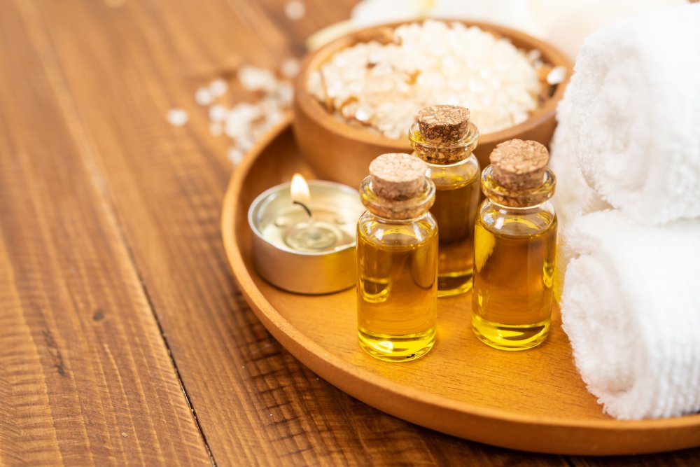 Benefícios da aromaterapia na vida: dicas e truques 3 sea salt towels aroma oil bottles flowers vintage wooden background