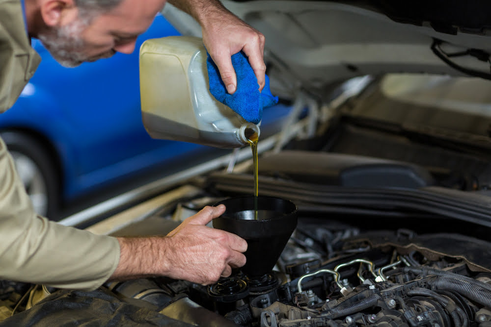 5 Dicas para prolongar a vida útil do veículo 2 mechanic pouring oil into car engine