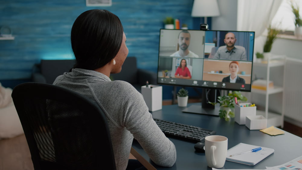 7 itens para renovar o home office e começar o ano com mais gás 3 black student discussing marketing academic ideas with college team having virtual teleconference meeting sitting desk living room