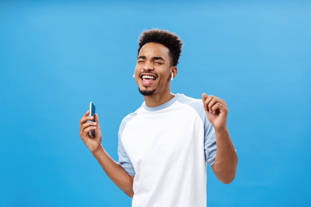 Fone bluetooth: saiba tudo sobre fones de ouvido sem fio 3 portrait pleased carefree handsome stylish urban african american male casual tshirt danci