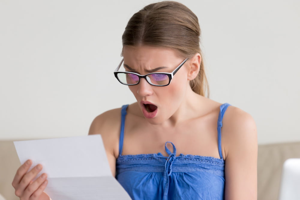 Multas em rodovias: 6 infrações mais comuns em estradas 3 woman shocked when reading letter with bad news