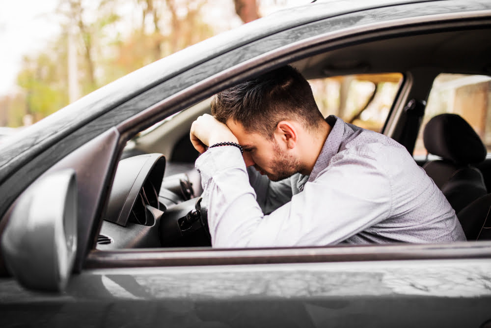 Multas em rodovias: 6 infrações mais comuns em estradas 2 young man sitting car very upset stressed after hard failure moving traffic jam