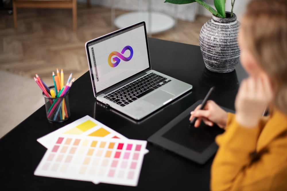 female logo designer working her tablet connected laptop