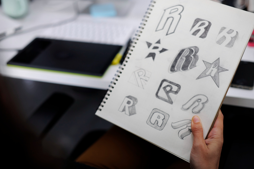 hand holding notebook with drew brand logo creative design ideas 1